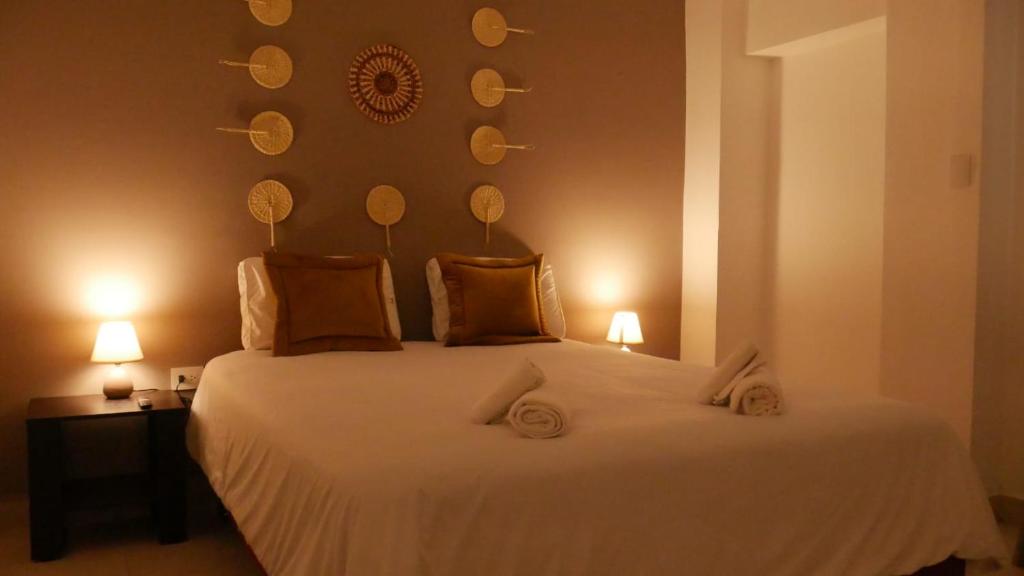 a bedroom with a large white bed with two lamps at Park View Hostel & Suites in Manta