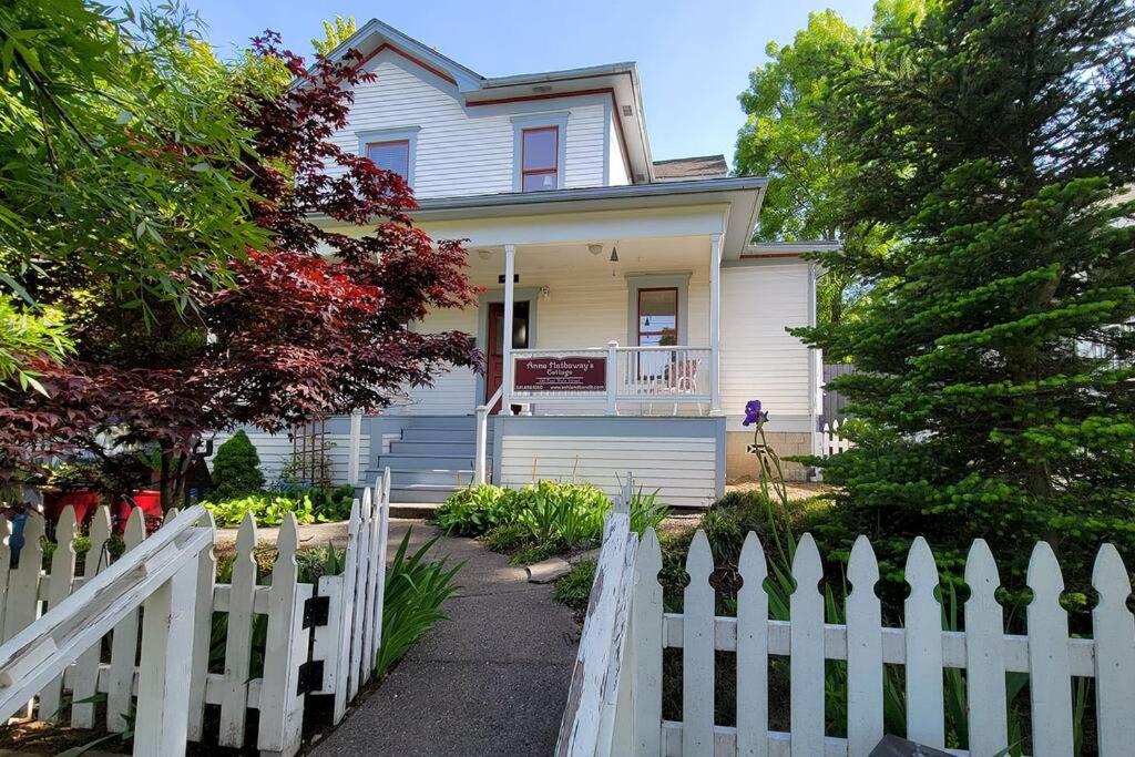 a white picket fence in front of a white house at Bluemoon Vacation Rentals - Anne Hathaway House in Ashland