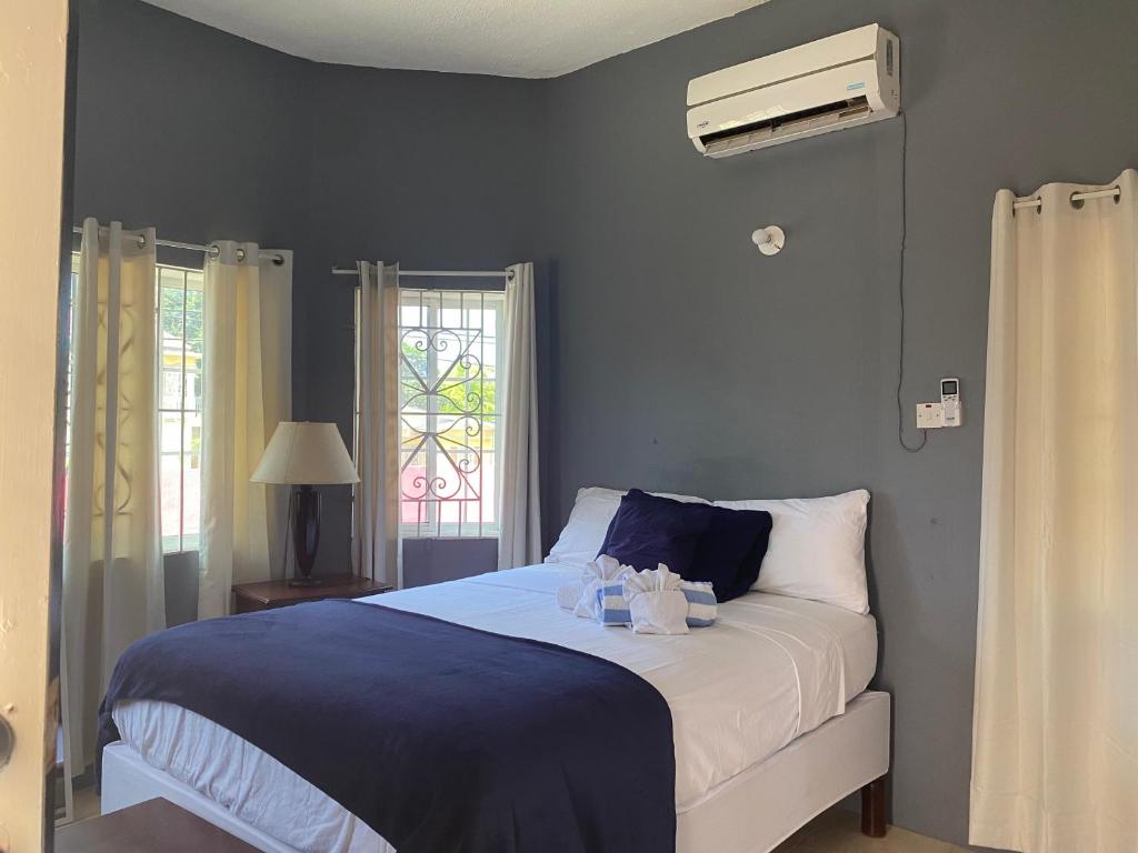 - une chambre avec un lit aux murs bleus et une fenêtre dans l'établissement A taste of Jamaica Lavern’s Place, à Ocho Rios