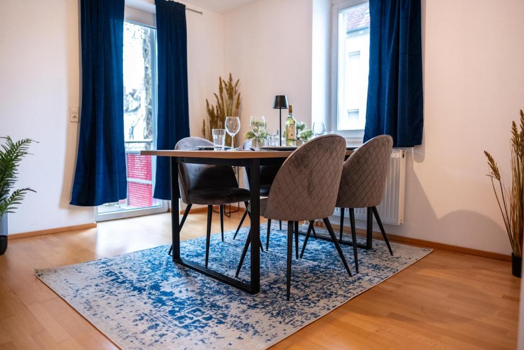 a dining room with a table and chairs on a rug at Klassen Apartments! Schnuckeliges Apartment - mit Balkon -in Bad Saulgau -für vier Personen - 1 OG in Bad Saulgau