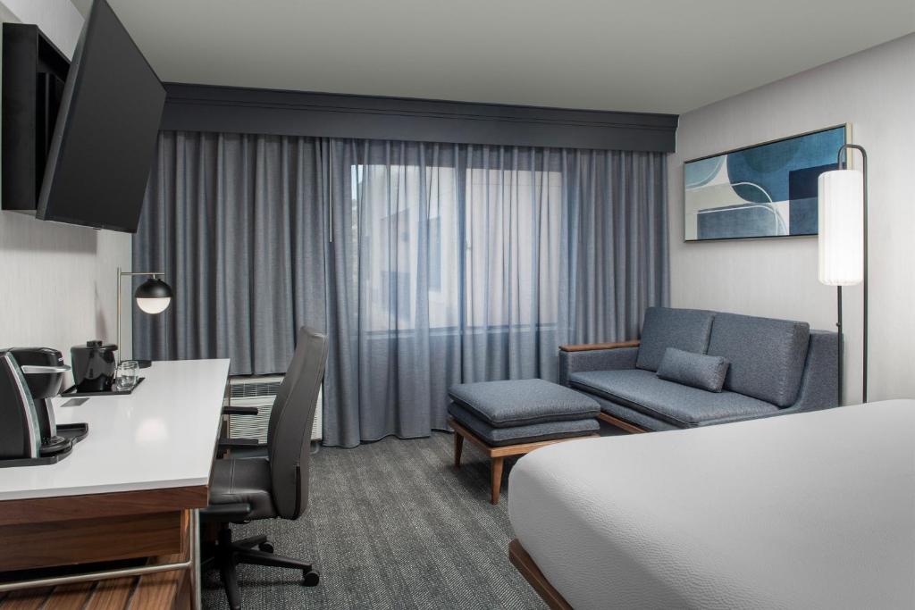 a hotel room with a bed and a desk and a computer at Courtyard by Marriott San Diego Carlsbad in Carlsbad