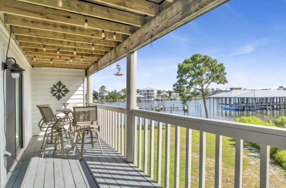 a porch with a table and chairs and a view of the water at Cotton Bayou Unit 8B in Orange Beach