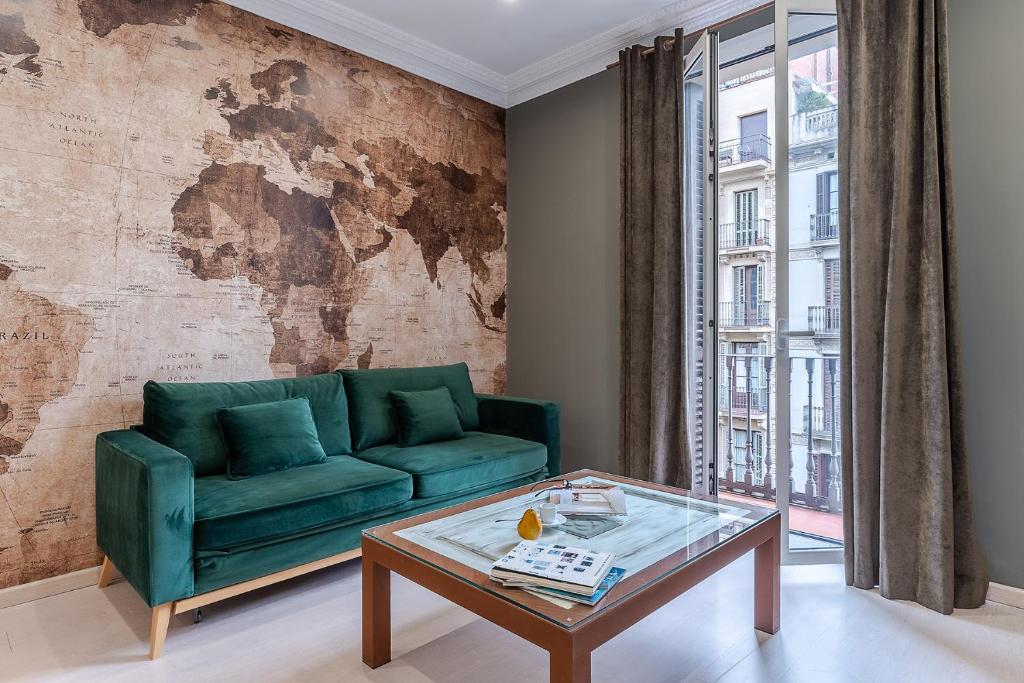 a living room with a green couch and a table at Enjoybcn Tapies Apartment in Barcelona