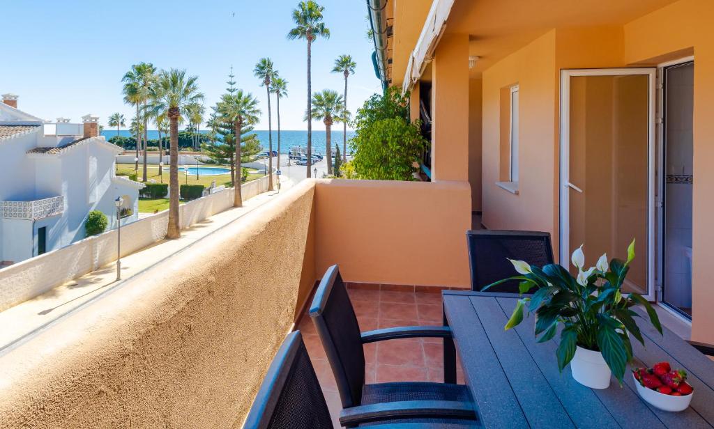 balcón con mesa, sillas y vistas al océano en Fantastic Apartment 80m from the Beach!, en Marbella