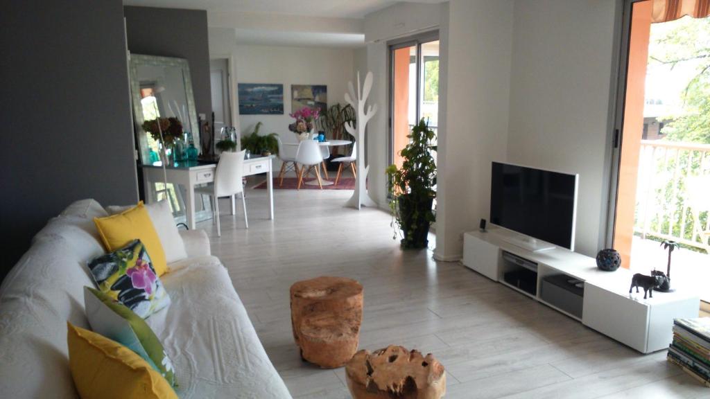 un salon avec un canapé blanc et une télévision dans l'établissement CONFORTABLE T3 sur BALCON à 5 MN du Centre Ville, à Bayonne