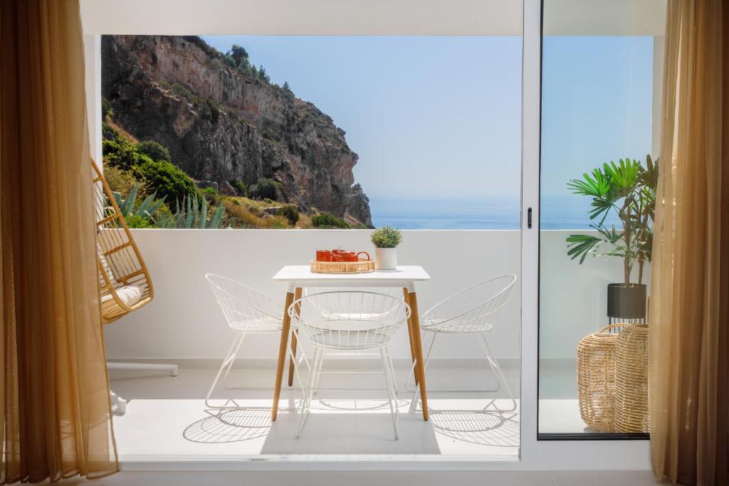 d'une table et de chaises sur un balcon avec vue sur l'océan. dans l'établissement Sesimbra Beach House by Saudade, à Sesimbra