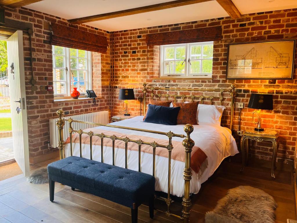 um quarto com uma cama e uma parede de tijolos em The Lion em East Bergholt