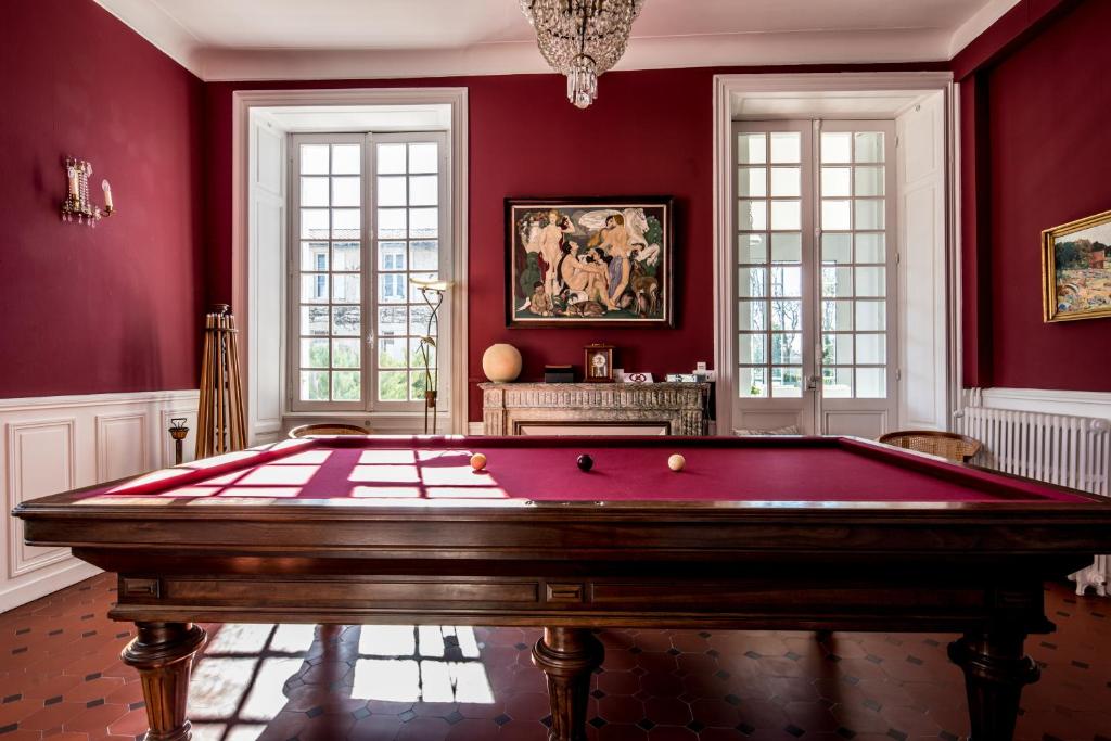 a red room with a pool table in it at Gîte Château de Seguin in Lignan-de-Bordeaux