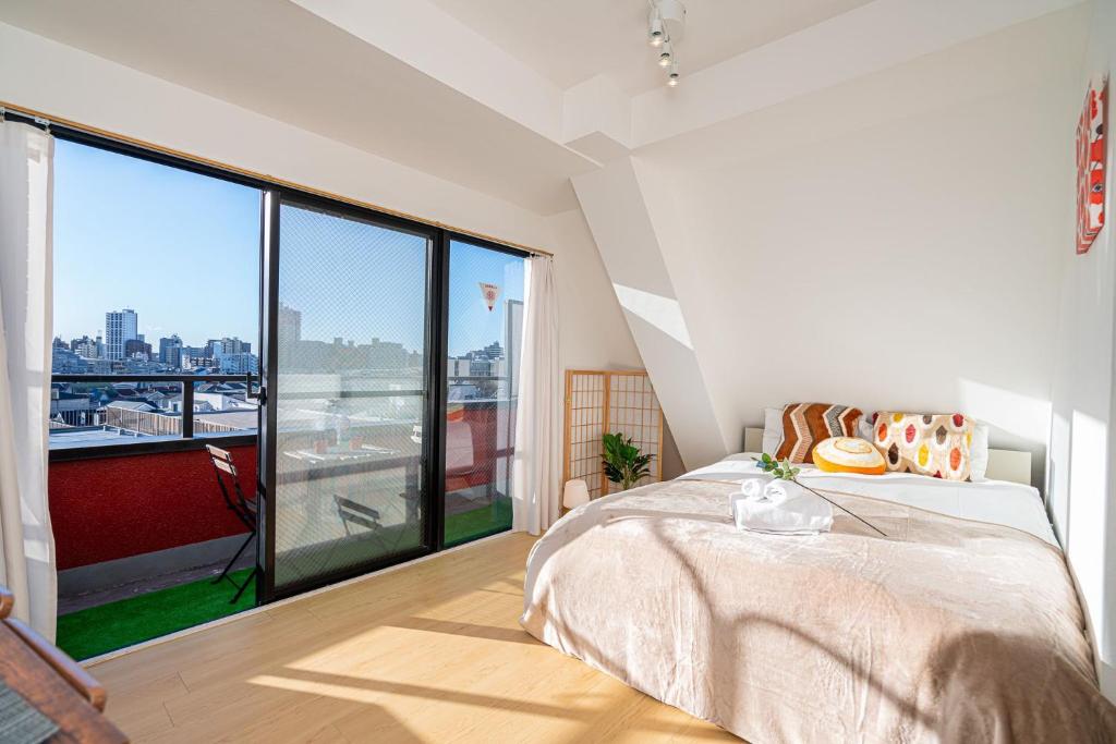 a bedroom with a bed and a large window at Aurora 5 in Tokyo