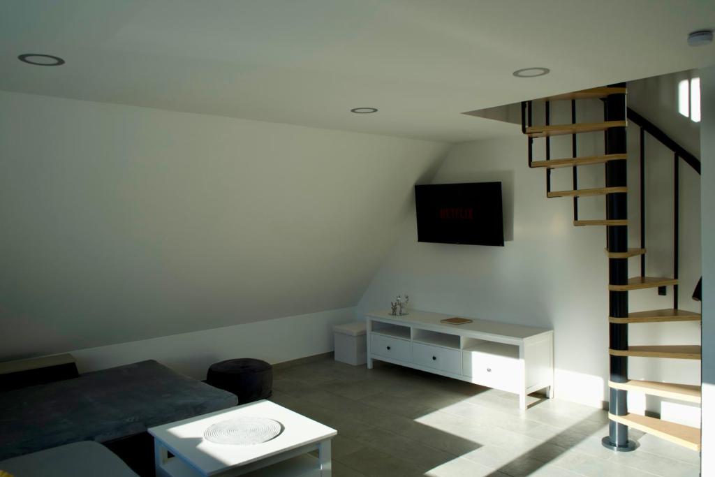 ein Wohnzimmer mit einer Treppe und einem Tisch in der Unterkunft Haus Allgäu Wohnung Wertachauen in Türkheim