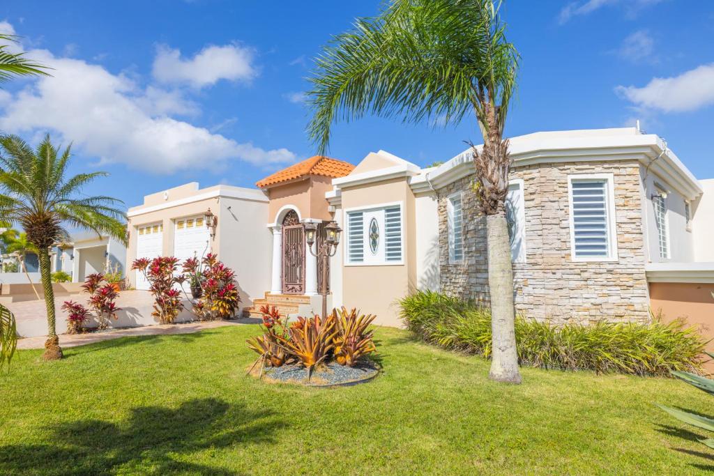 une maison avec un palmier dans une cour dans l'établissement Big Vacation House, à Moca