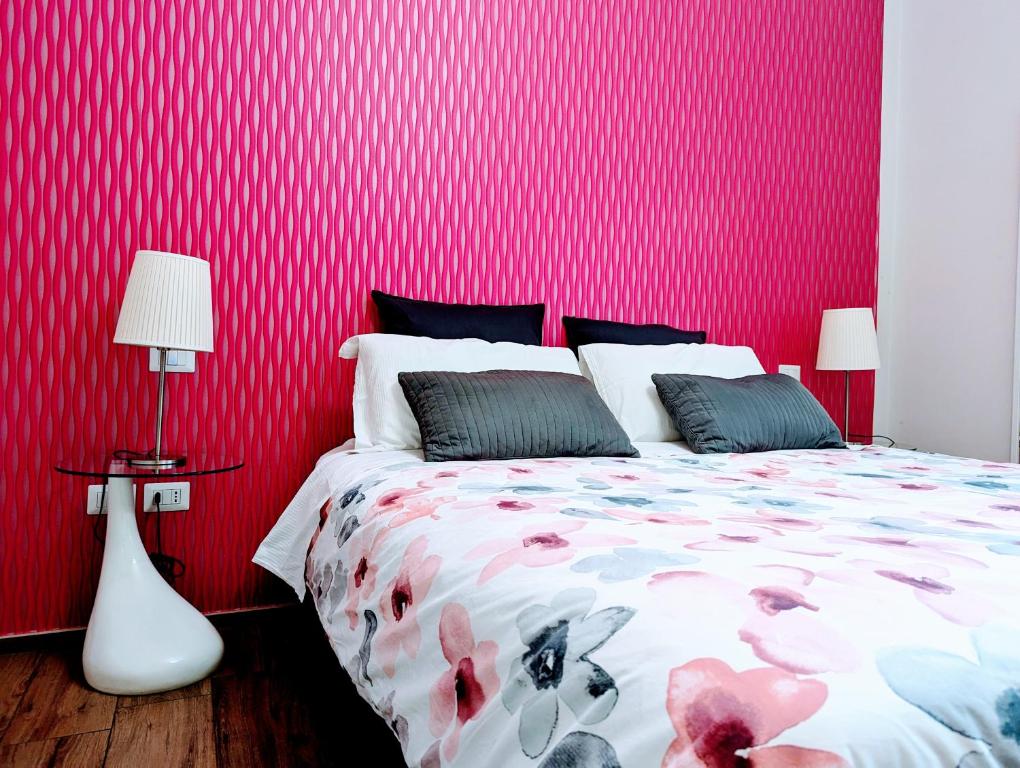 サレルノにあるgia'Notte BB Salerno Centro by ElodeaGroupの赤い壁のベッドルーム1室(ベッド1台、ランプ2つ付)