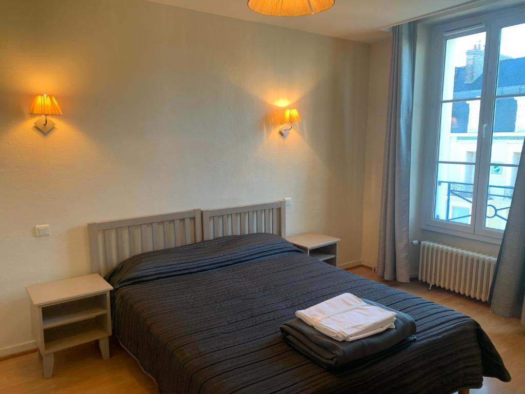 a bedroom with a bed with two tables and two lamps at Résidence Le Rochebonne in Saint Malo