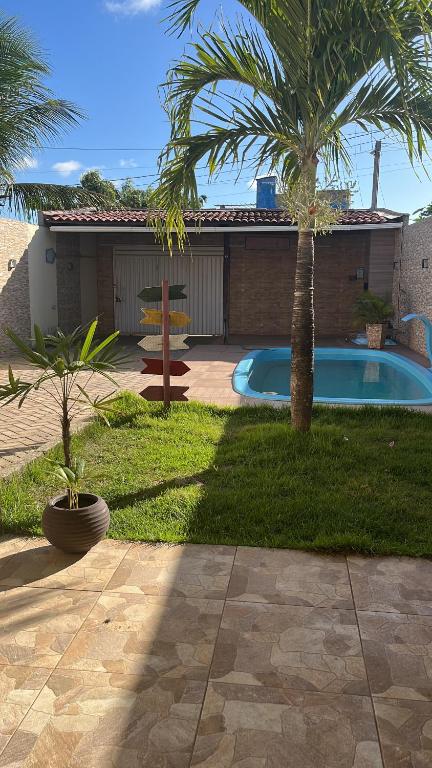 um quintal com piscina e palmeiras em Casa de Praia Muriu Beach em Ceará-Mirim
