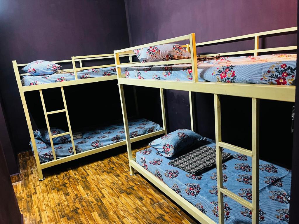 2 Etagenbetten mit einem Stuhl in einem Zimmer in der Unterkunft Hostel kuruku santhu colive in Puducherry