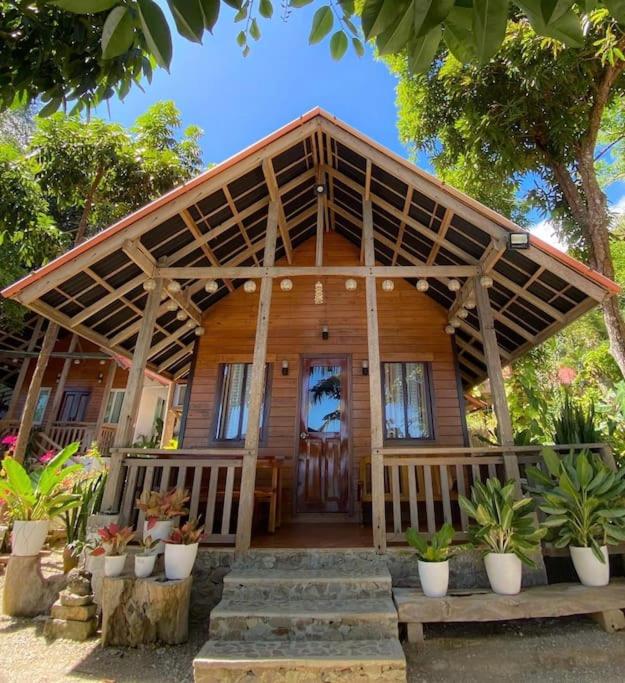 a large wooden house with a large wooden porch at Cabin A at Bigang Munti in Batangas City