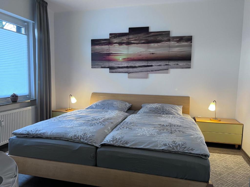 a bed in a bedroom with two paintings on the wall at Allee zum See in Schüttorf