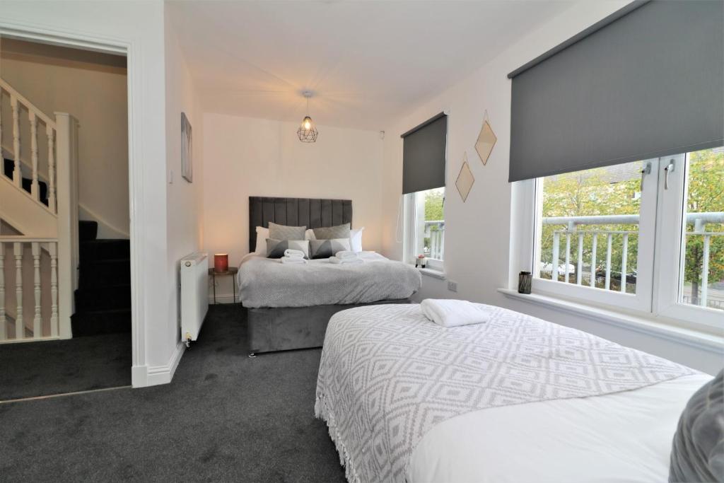 a bedroom with two beds and a staircase at Signature - Belvidere House in Glasgow