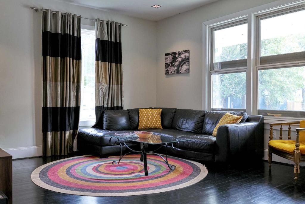 sala de estar con sofá de cuero negro y mesa en Beautiful Historic Downtown Pensacola Charmer en Pensacola