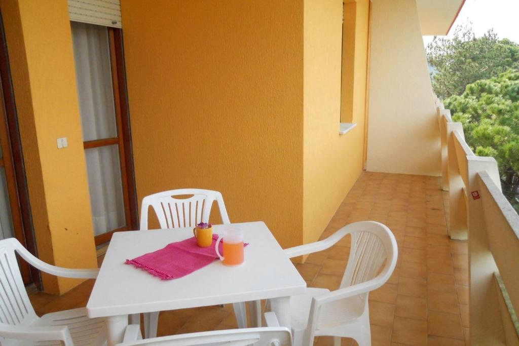 - une table et des chaises blanches dans la chambre dans l'établissement Bright flat with a wide terrace - Beahost Rentals, à Bibione
