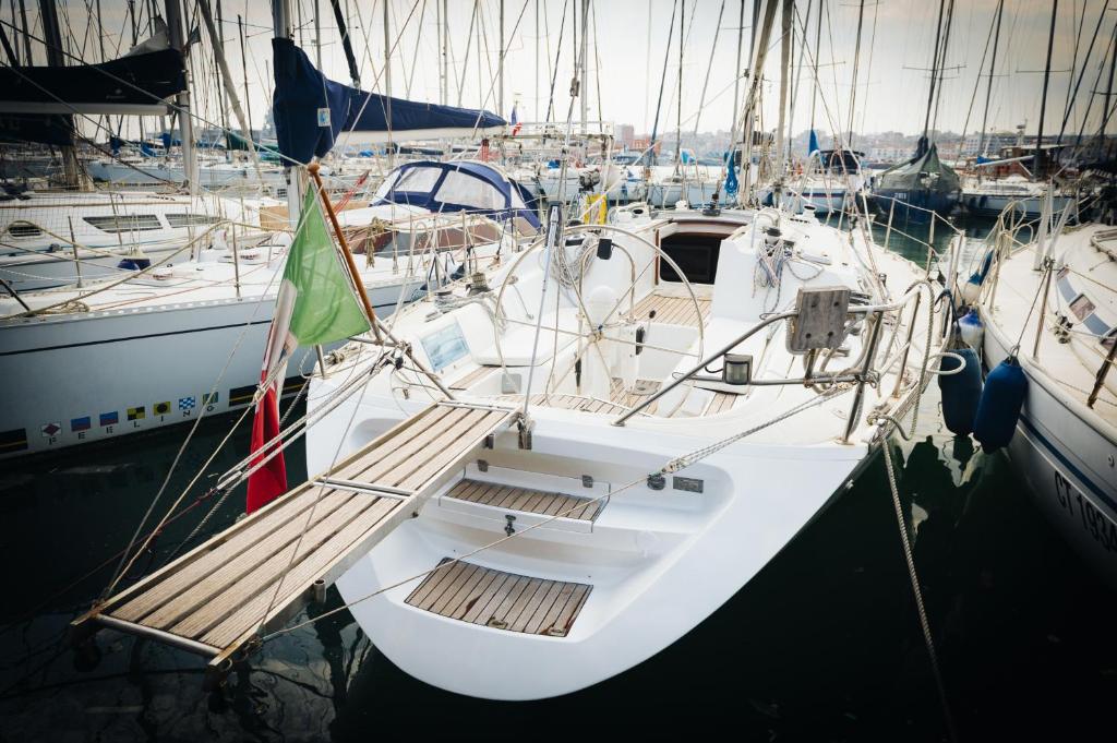 una barca bianca è ormeggiata in un porto di Sleep in boat a Catania