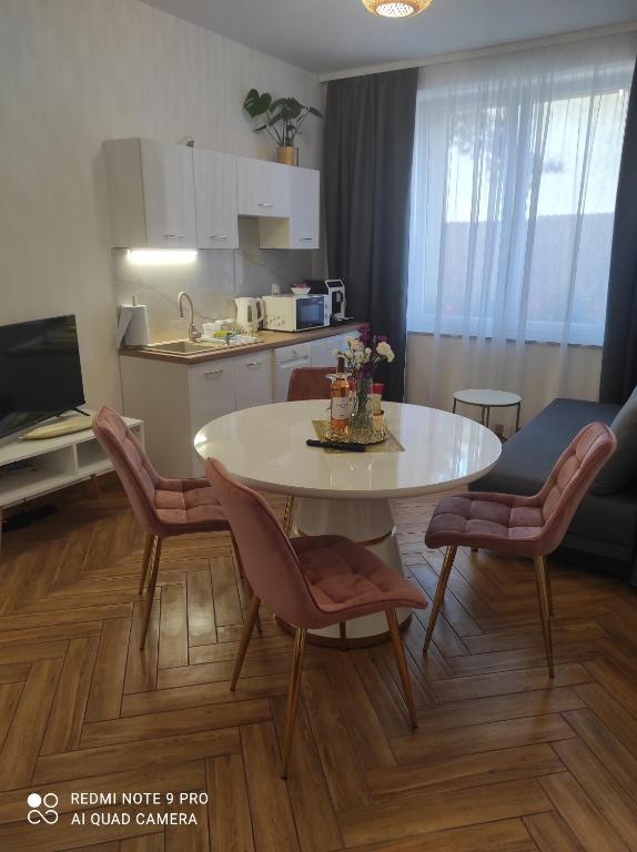 a kitchen and dining room with a table and chairs at Apartament Dawna Mleczarnia Apartament Sosnowy in Nowa Ruda