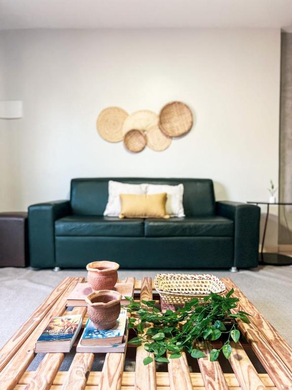 a living room with a green couch and a coffee table at Rize Studios in Maceió