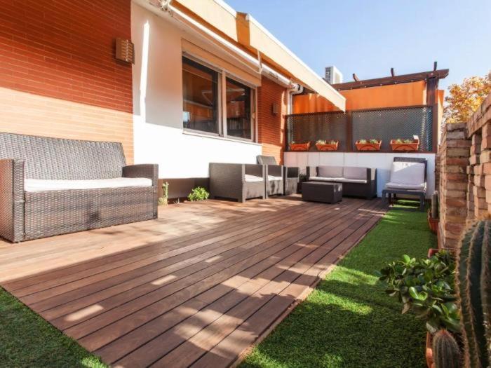 une terrasse en bois avec un canapé et des chaises. dans l'établissement Spectacular central Penthouse with private terrace, à Séville