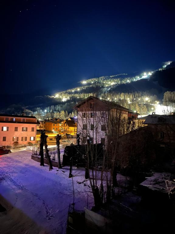 a person walking in the snow at night at Giava’s Mountain Place Aprica in Aprica