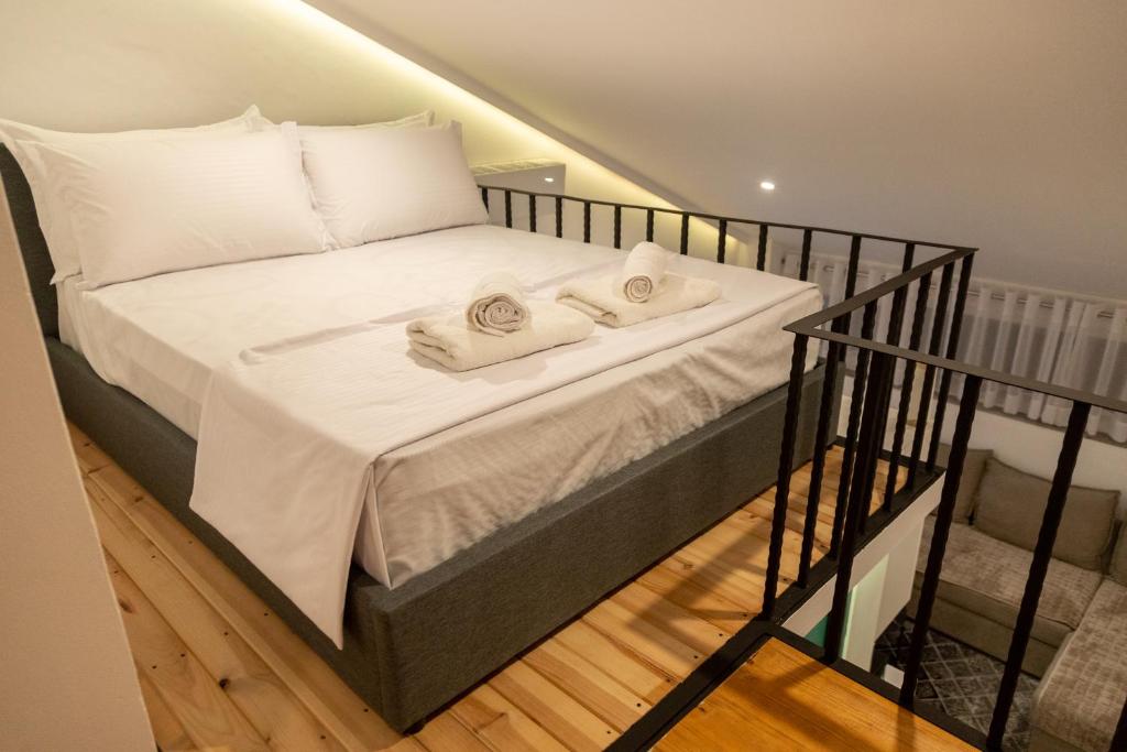 Una cama con toallas en una habitación en Cozzy Loft-Blloku Downtown, en Tirana