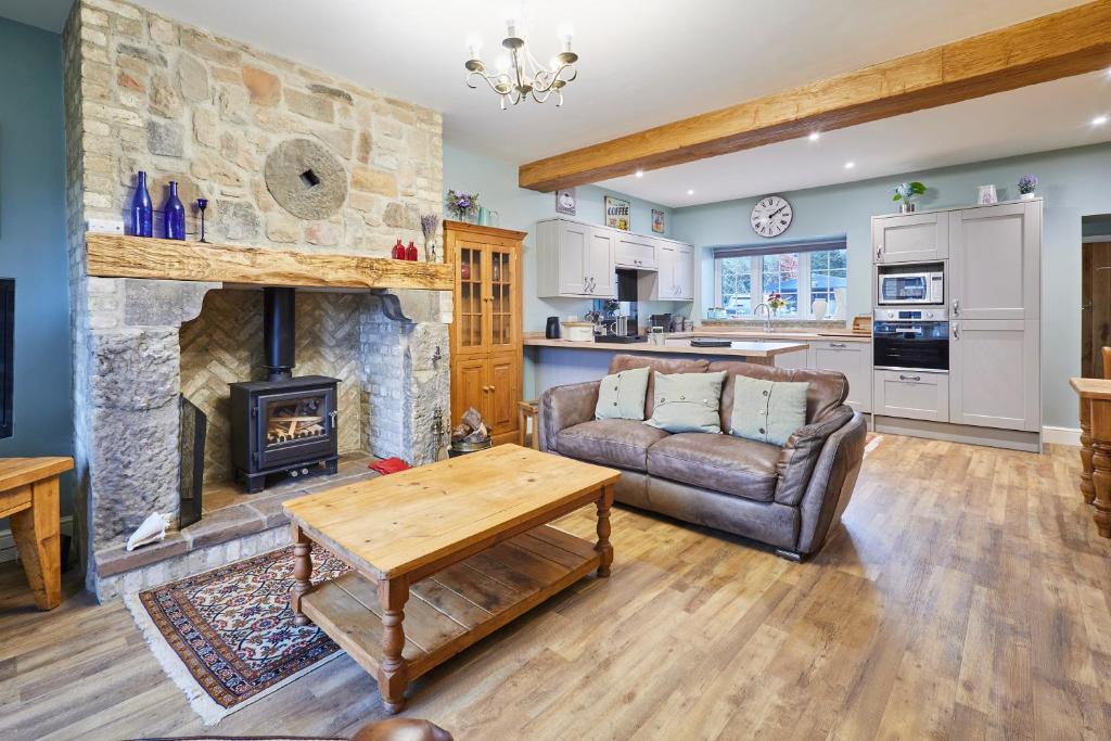 a living room with a couch and a fireplace at Host & Stay - Butterfly Cottage 