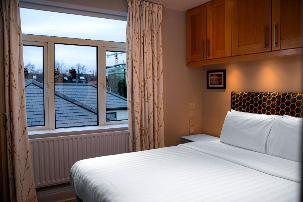 a bedroom with a bed and a large window at Warner's Collection in Dublin