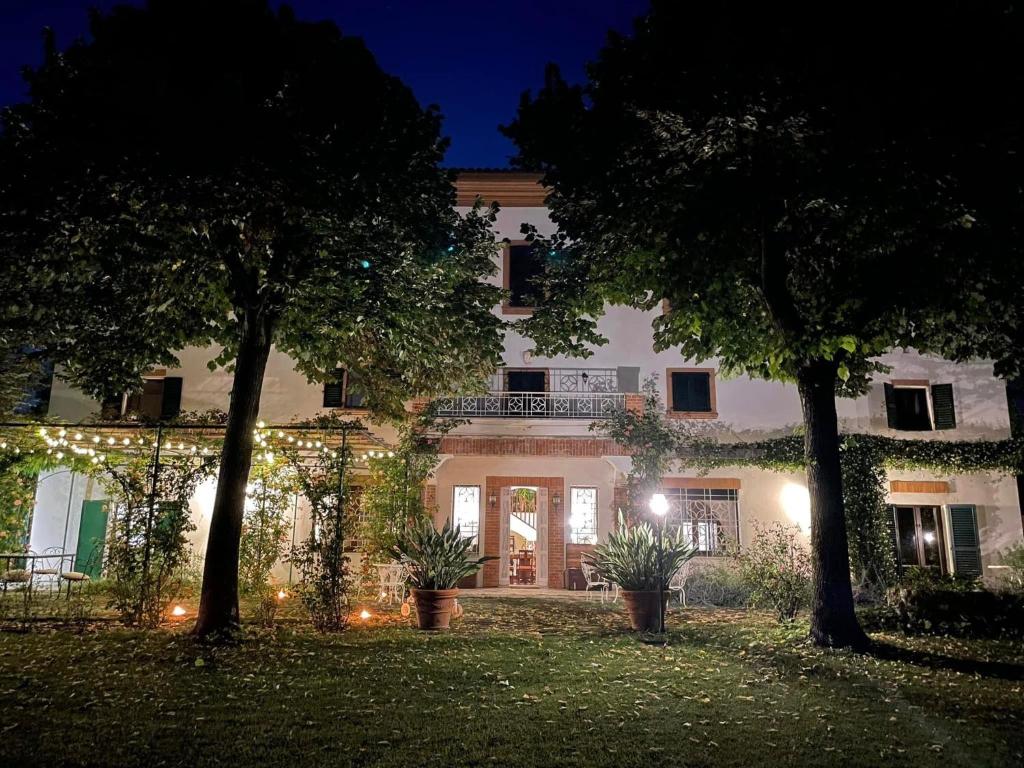 un grande edificio bianco con alberi di fronte di Dimora Rosa Bianca a Macerata