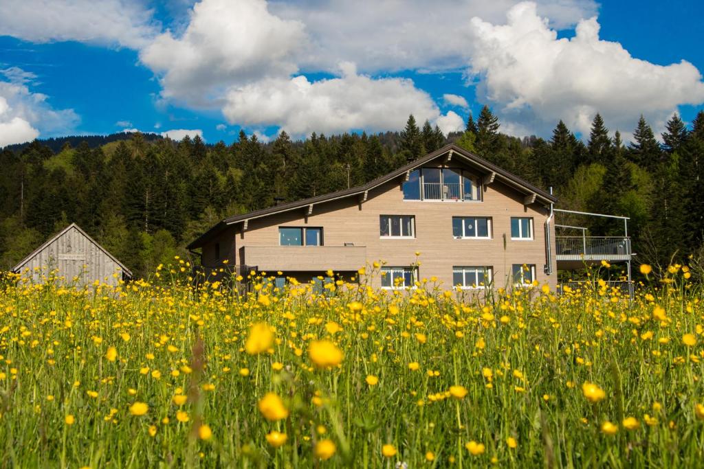 a house in the middle of a field of flowers at Haus Feurstein in Hittisau