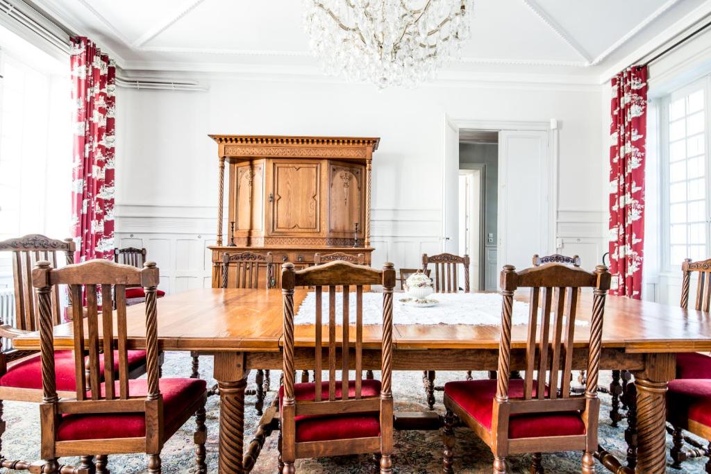a dining room with a large wooden table and chairs at Gîte Château de Seguin in Lignan-de-Bordeaux