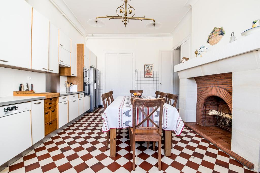 a kitchen with a table and a fireplace at Gîte Château de Seguin in Lignan-de-Bordeaux