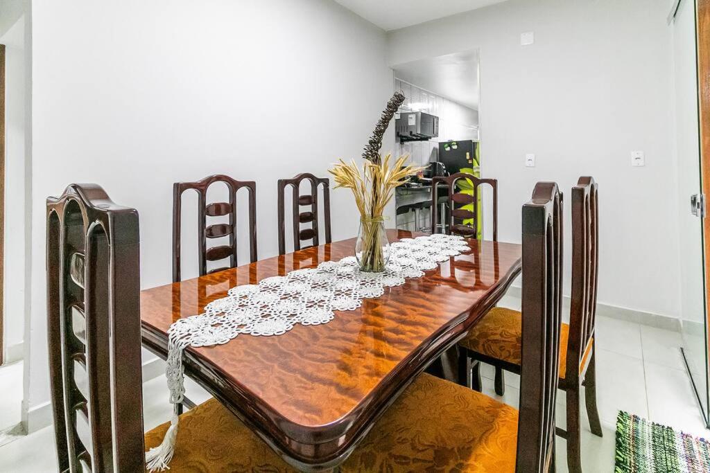 a dining room with a wooden table and chairs at Casa Água Branca, Contagem - prox.arena MRV in Contagem