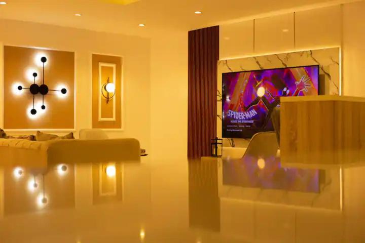 Una sala de estar con un sofá y un televisor en Atelier Lux Homes- Modern Service Apartments with Amazing Designs, en Ibadán