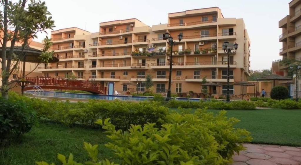 un gran edificio de apartamentos con un parque enfrente en شقة فندقية en Qaryat ash Shamālī