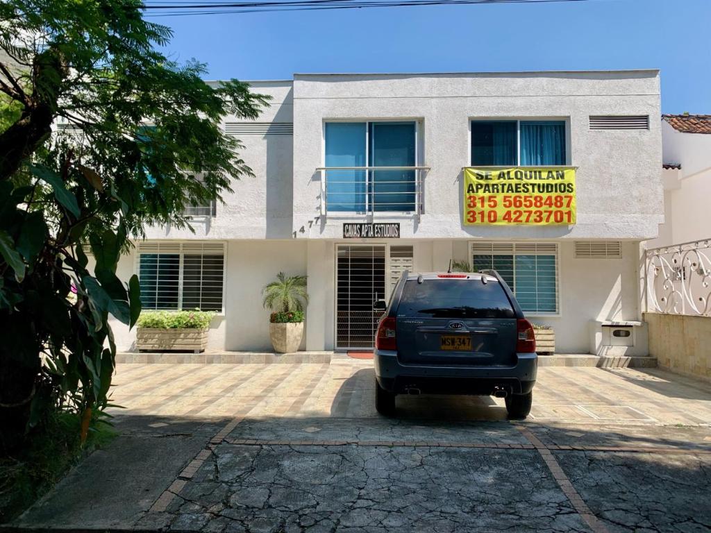 un coche aparcado frente a un edificio con una señal en Cavas AP, en Cali