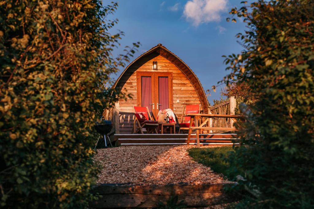 a cabin with two chairs and a red door at Eco Pod 1 in Yarmouth