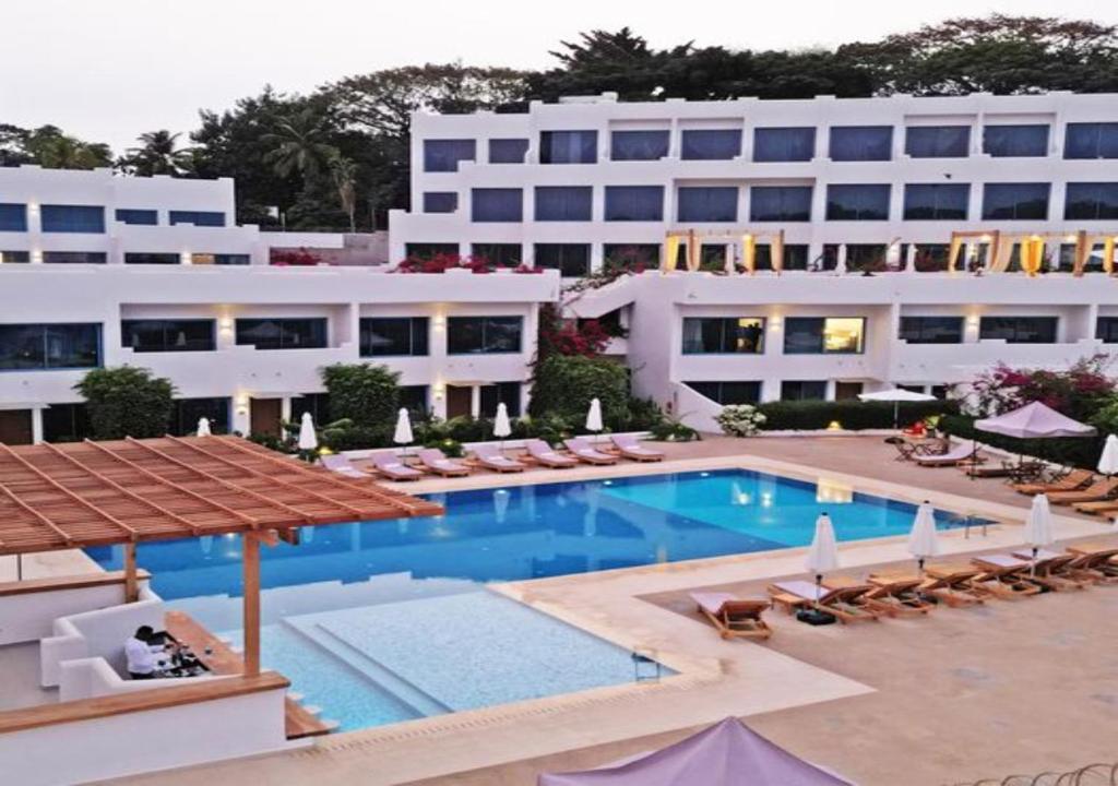 a hotel with a swimming pool and a large building at The Lead Hotel in Freetown