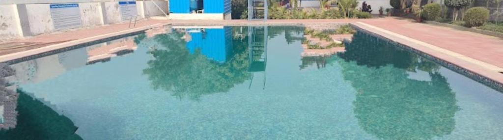 a large pool of blue water with trees in it at M.D. Grand Hotel N Resort in Agra