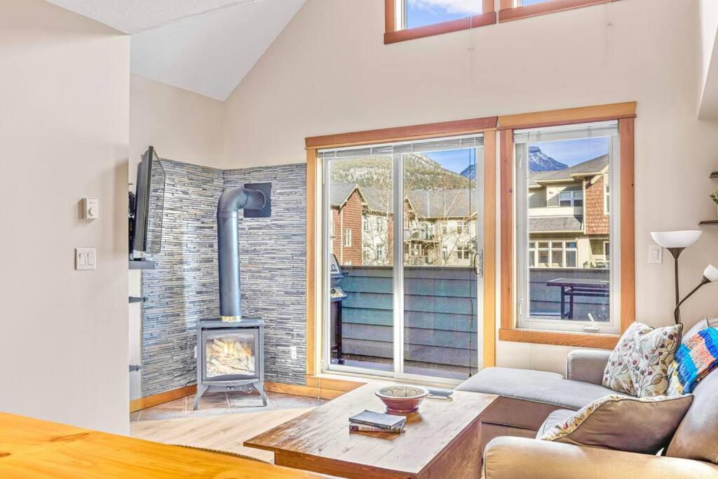 - un salon avec un canapé et une cheminée dans l'établissement Canmore Mountain view loft apartment heated outdoor pool, à Canmore