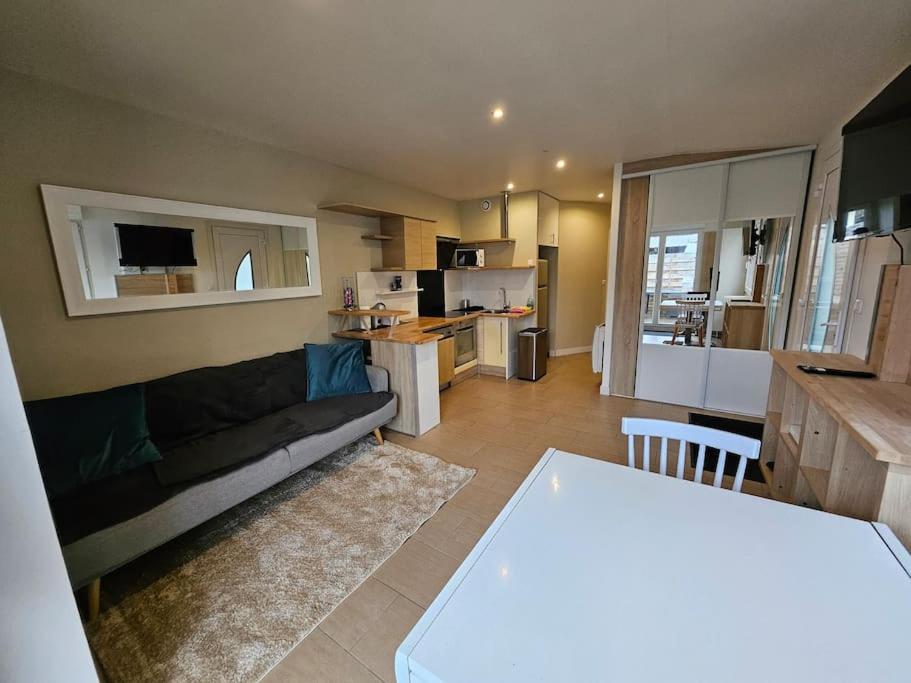 a living room with a couch and a kitchen at Le 301 Vercingétorix - Proche Paris & Disney in Champigny-sur-Marne