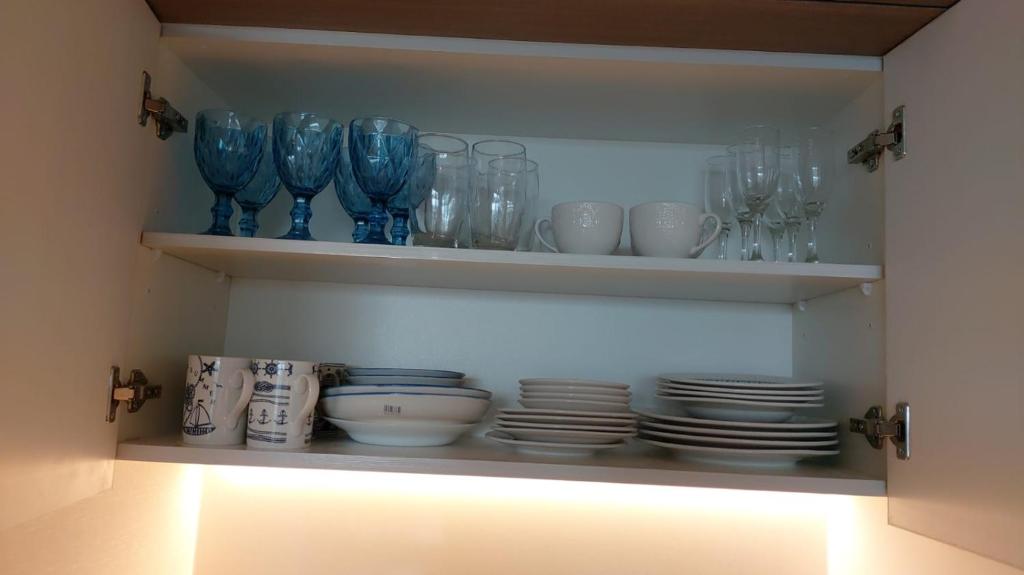 a cabinet filled with blue glass vases and plates at departamento concon in Concón