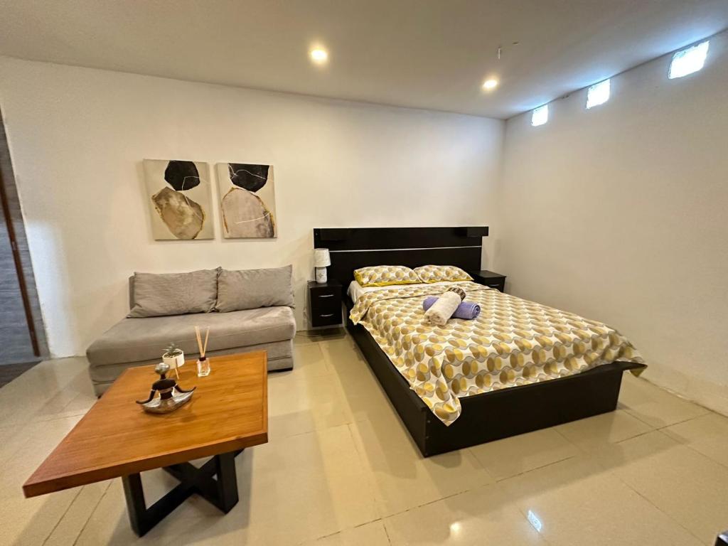 1 dormitorio con cama y mesa de centro en Suite Bosque de la Alborada B, en Guayaquil