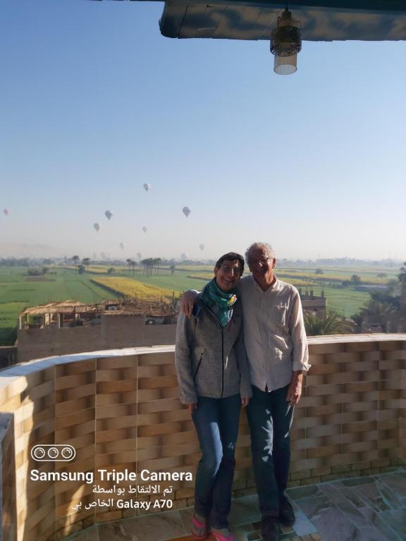 een man en een vrouw die bovenop een gebouw staan bij Happy home in Luxor