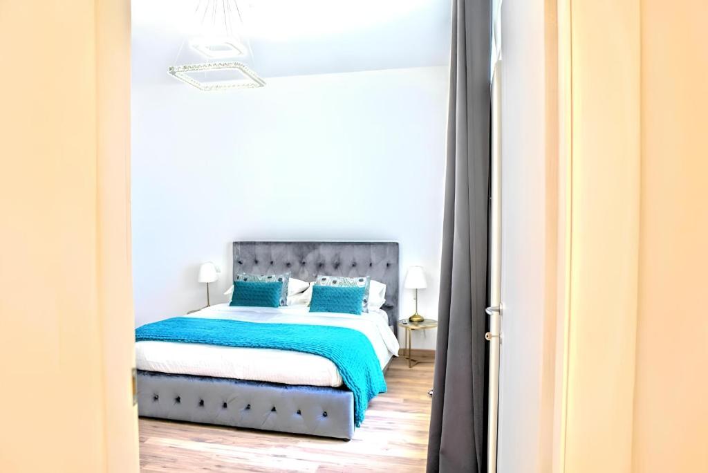 a bedroom with a bed with blue pillows at VUEL SEA VIEW HOUSE -10 Minutes from the Airport Fiumicino in Fiumicino