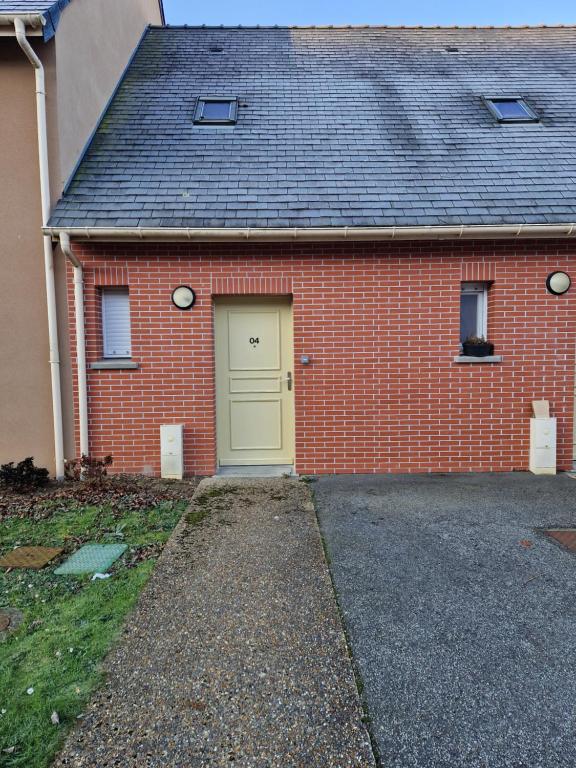 einem roten Backsteinhaus mit gelber Tür in der Unterkunft Maison à Saint sauveur 10 minutes d'Honfleur in La Rivière-Saint-Sauveur